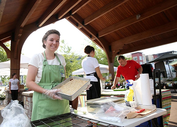 UW-Stout dietetics student Amanda Nass offers zucchini dessert squares at the Veggin’ Out booth at the Downtown Farmers’ Market in Eau Claire.