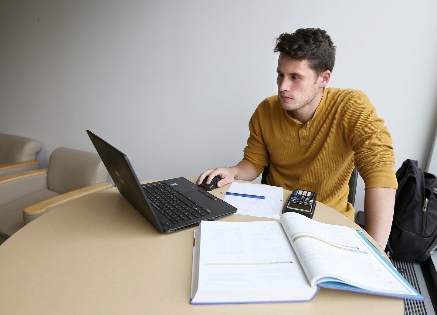 Student studying on a computer in a quiet corner of the university.