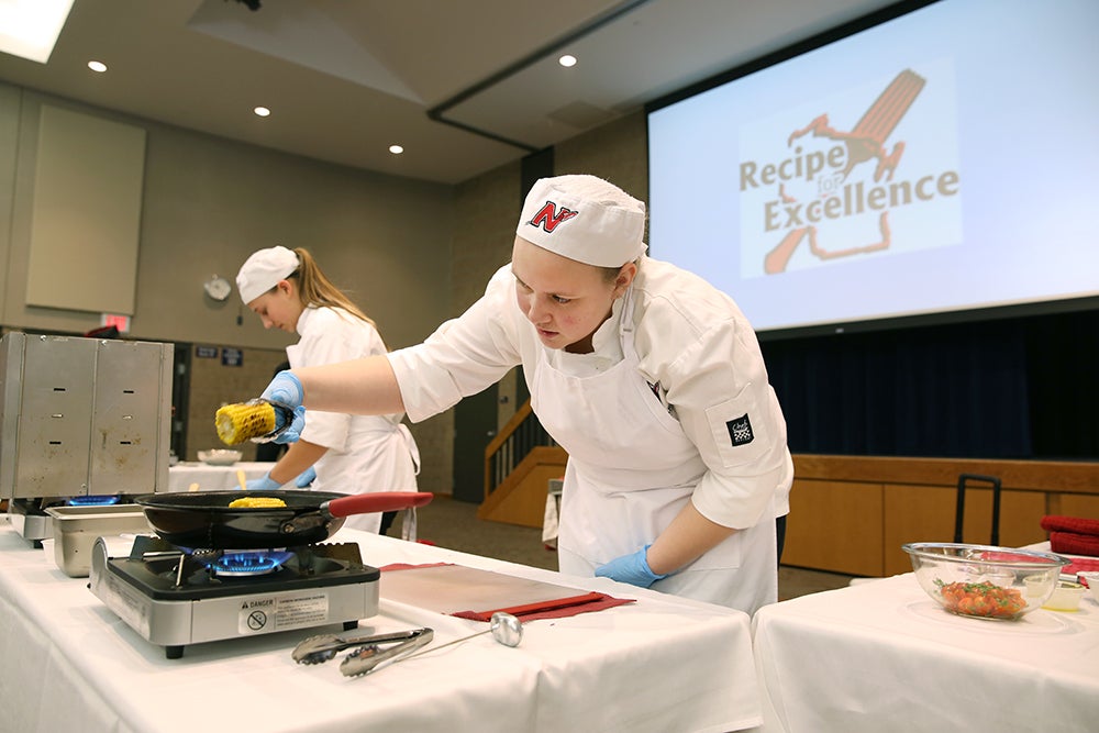 Neenah High School students Nikki Messick, at left, and Madelynn Hendriks work against the clock as they cook their competition dish in 60 minutes at UW-Stout’s Recipe for Excellence culinary competition Thursday, Feb. 8. The team won first-place.