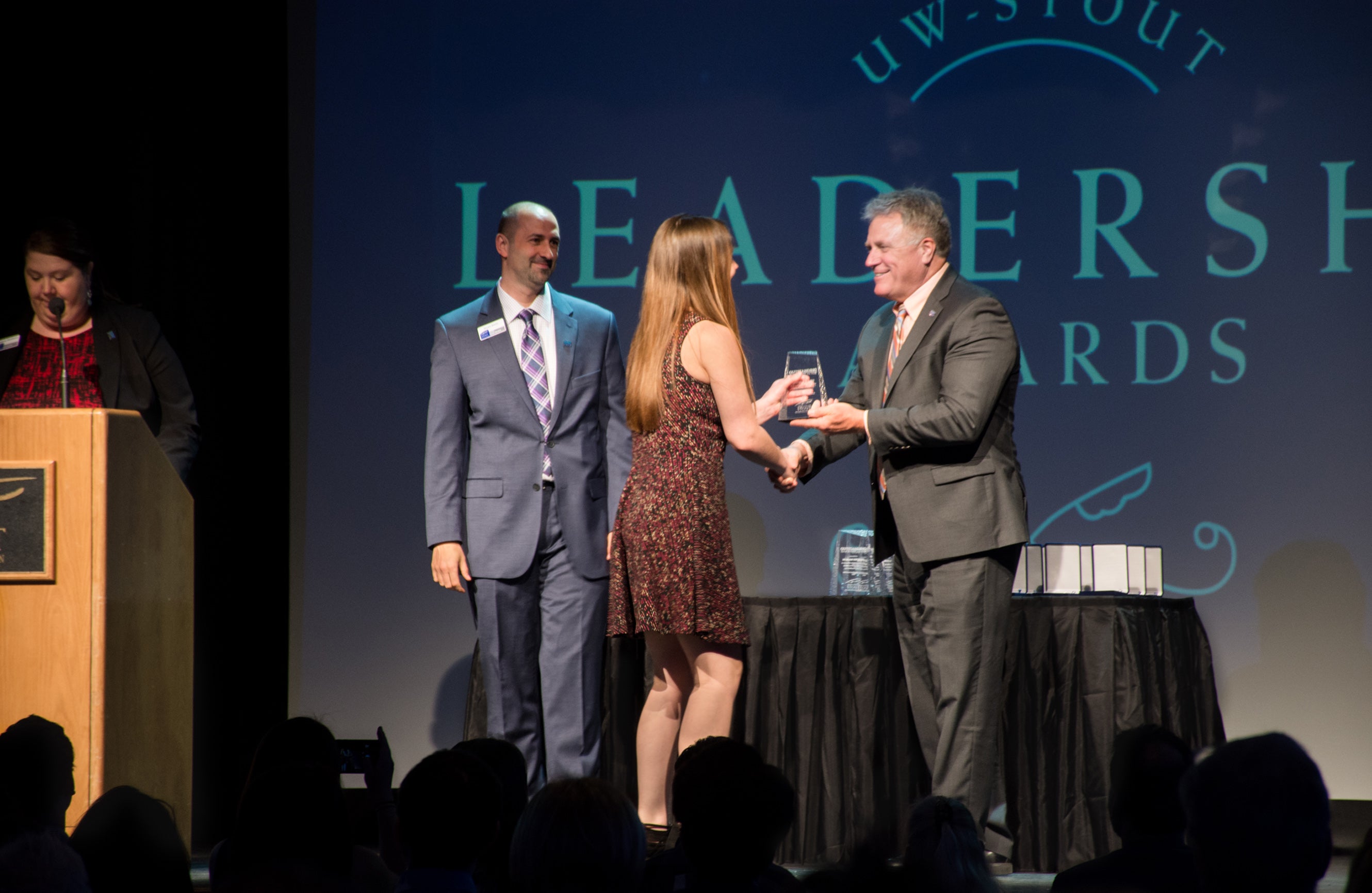 UW-Stout student Danielle Komro, a cross-media graphics management major, accepts an Outstanding Co-op Student of the Year Award from Bryan Barts, left, Career Services Director, and Chancellor Bob Meyer.