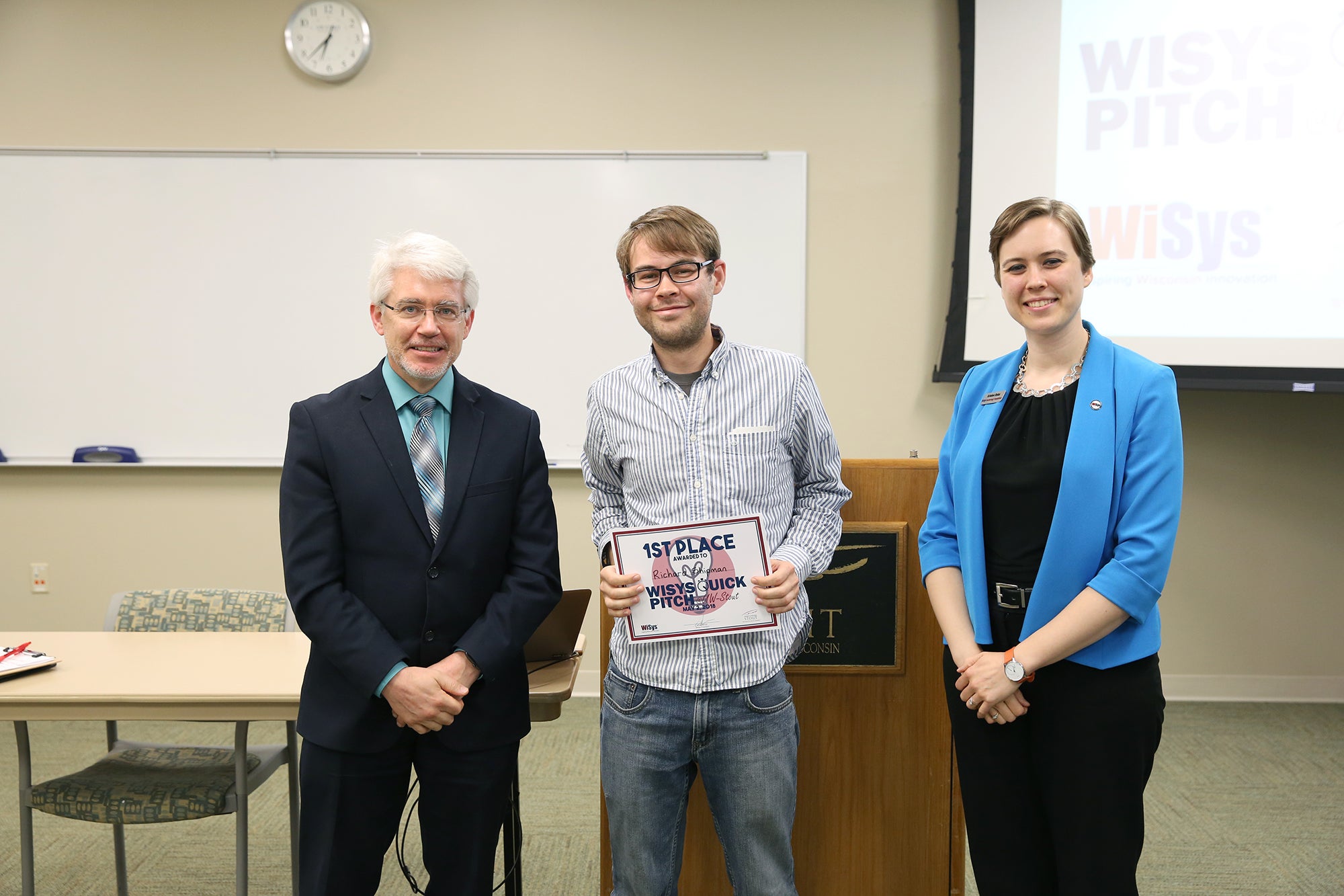 Richard “D.J” Shipman, at center, with UW-Stout Provost Patrick Guilfoile and Kristen Ruka, regional associate for WiSys Technology Foundation. Shipman won the UW-Stout WiSys Quick Pitch competition May 2. /UW-Stout photos by Brett T. Roseman.