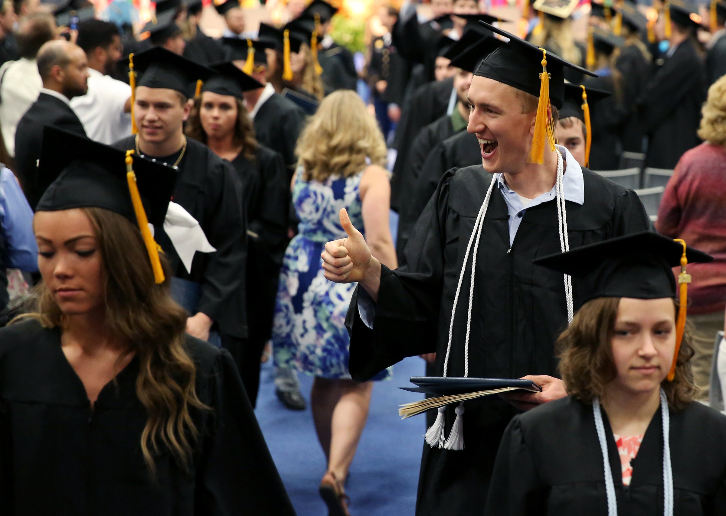 A happy Nick Richards, right, leaves Johnson Fieldhouse with his diploma May 5.
