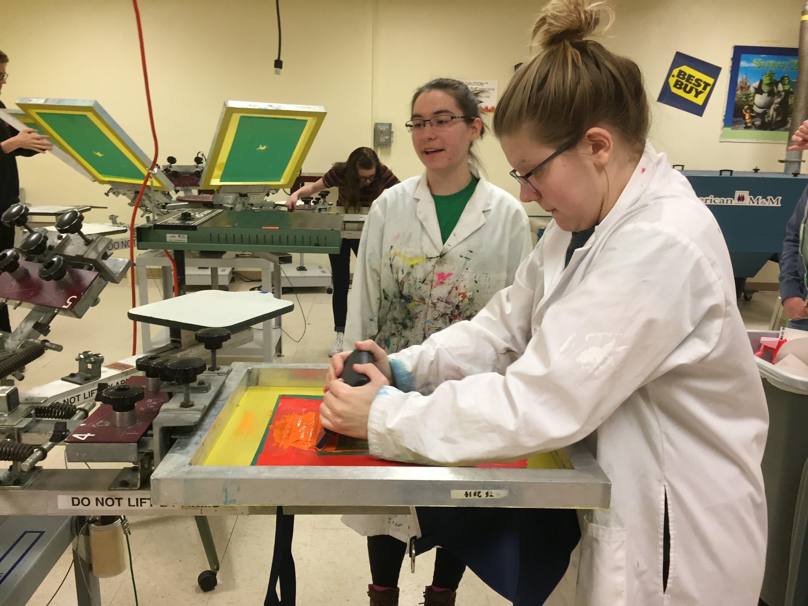 Jessica Kastello, at left, along with Hailey Vosen, both juniors at UW-Stout, screen printed the logo on to the smocks.