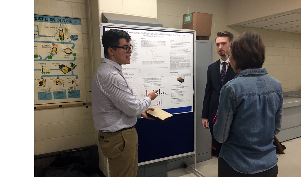 packaginghero UW-Stout packaging students Anthony Diaz, at left, and Jeff Wallace, talk about a light dampening package they created to help keep ground beef fresher longer. / UW-Stout photos by Pam Powers