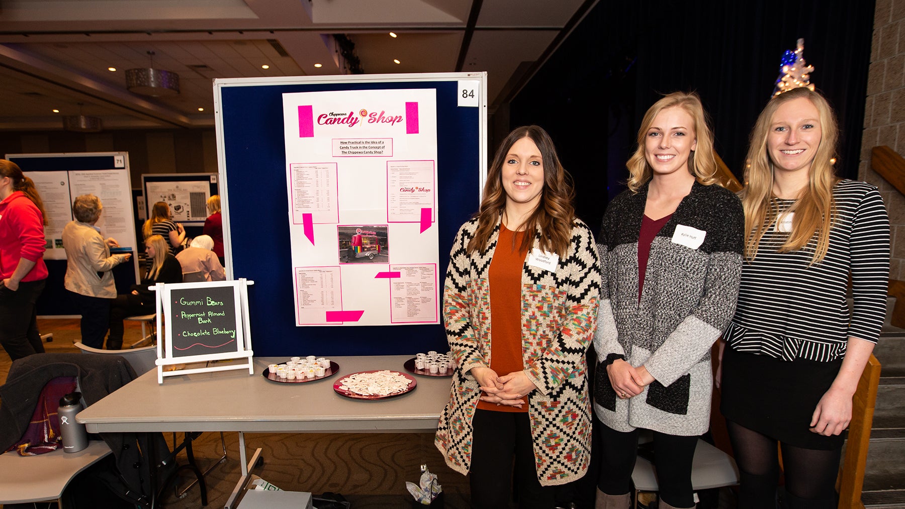 UW-Stout students Lindsey Woodford, at left, Kylie Hoff and Kristin Utech with their research on the feasibility of the Chippewa Candy Shop in Chippewa Falls starting a candy truck. / UW-Stout photo by Chris Cooper