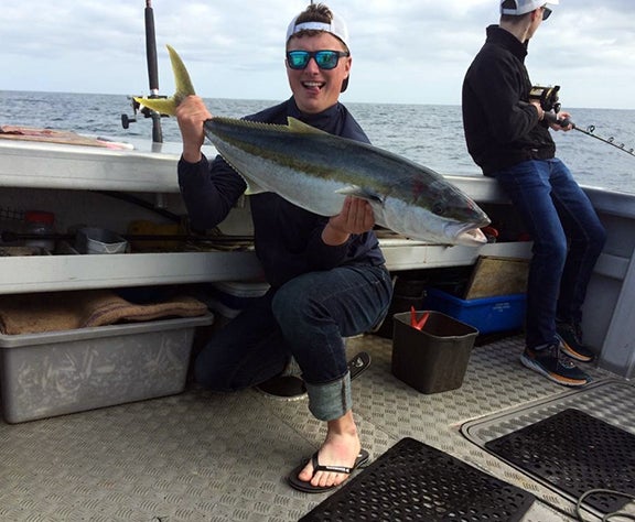 Sam Klobucar shows off a kingfish he caught while in New Zealand.