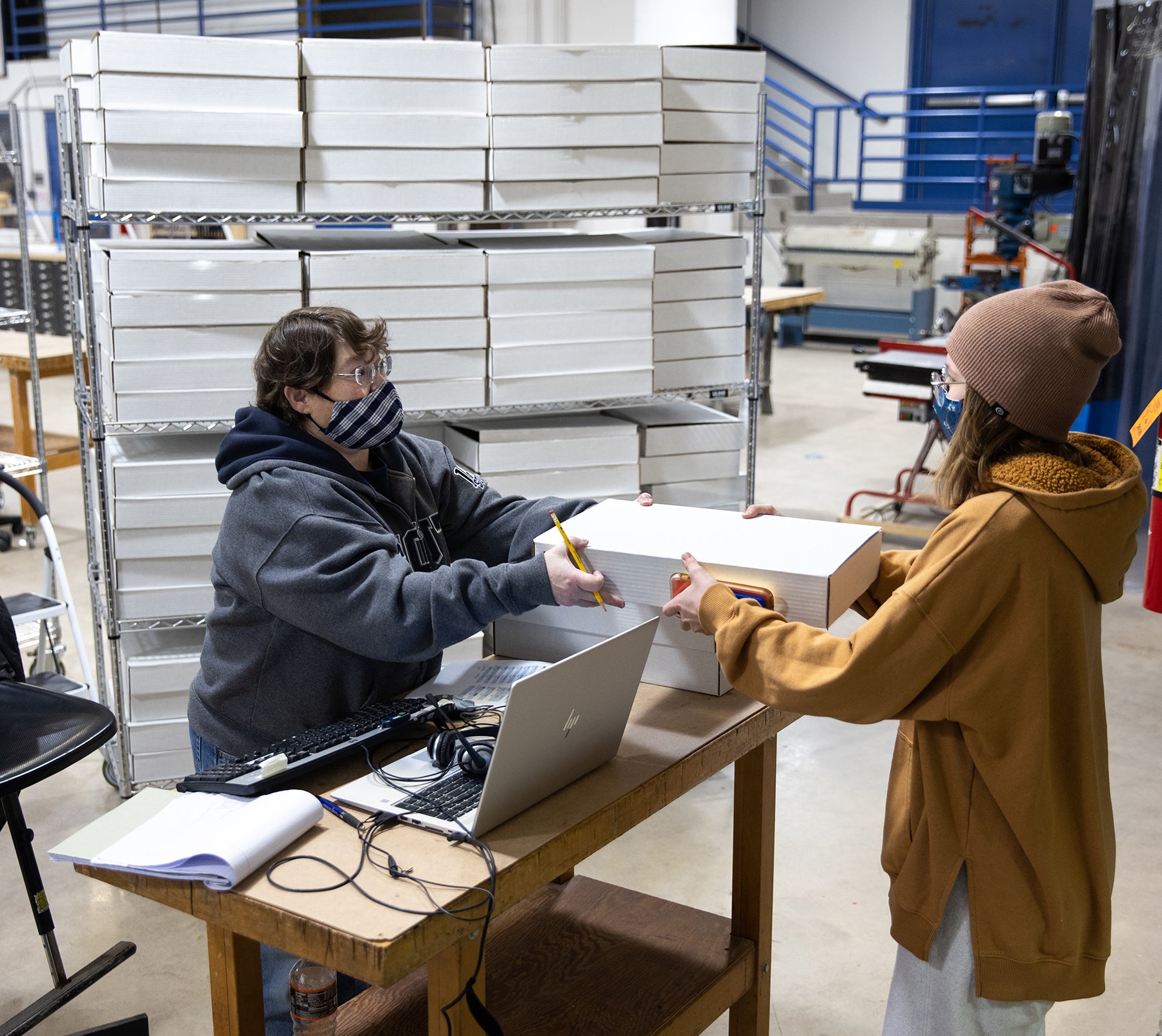 Cathie Weissman, UW-Stout School of Art and Design staff member, hands out a kit to a student in the 3D Design Foundations class.