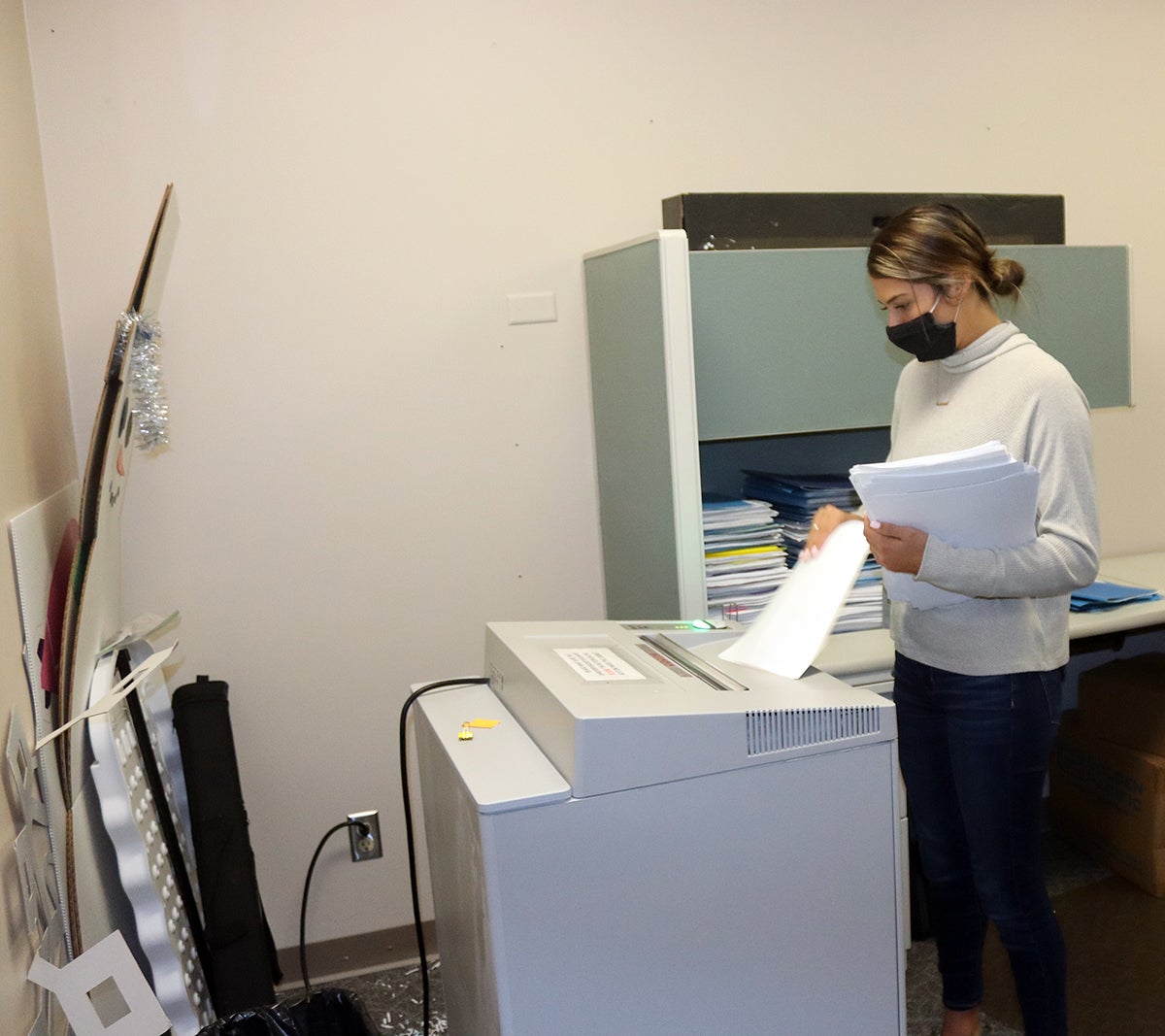 UW-Stout student Heather Kent, a senior business administration major from Altoona, shreds office paper in the Human Resources office.