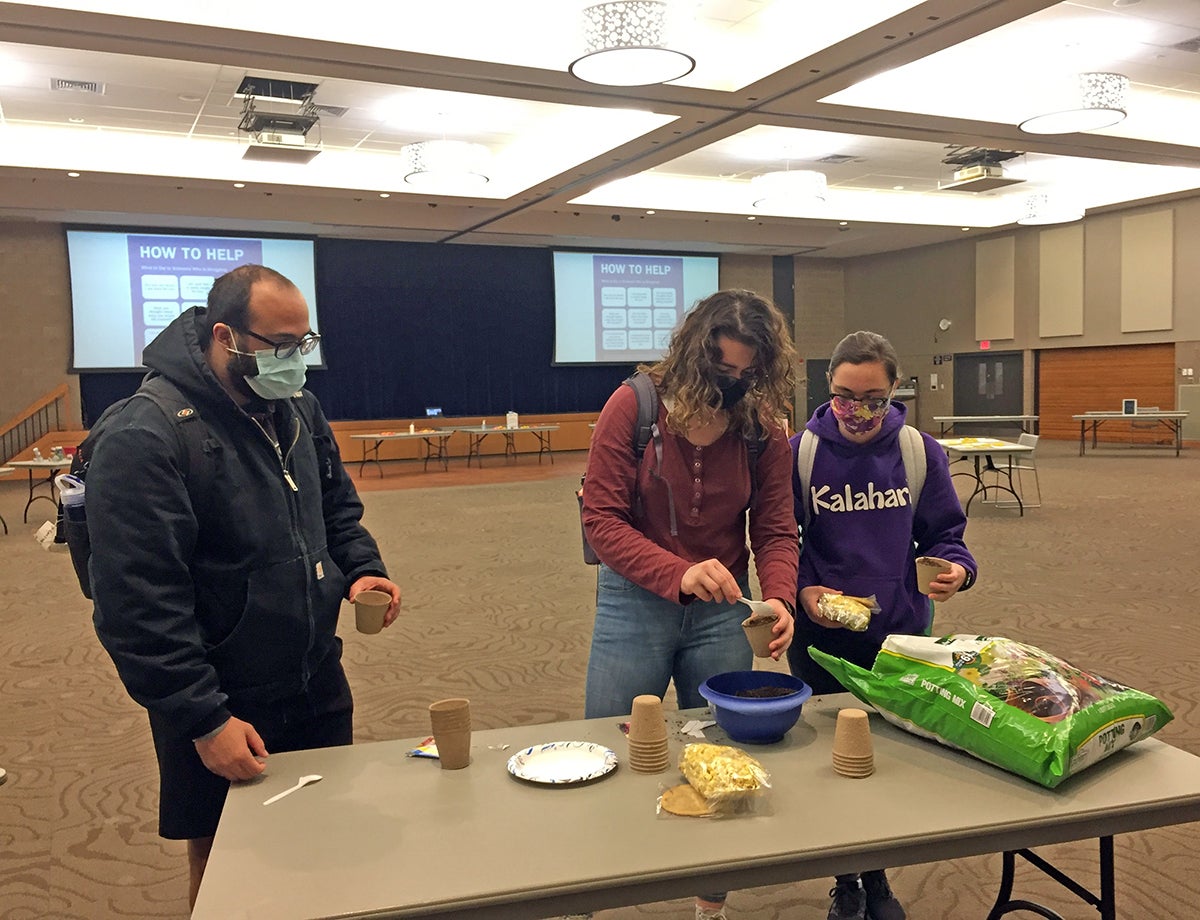 UW-Stout students Michael Wilson, at left, Amara Miller and Tori Williams plant flower seeds during the Self-Care is Everywhere event at UW-Stout. The Counseling Center and Student Life Services are holding events to help student cope with stress. /UW-Stout photo