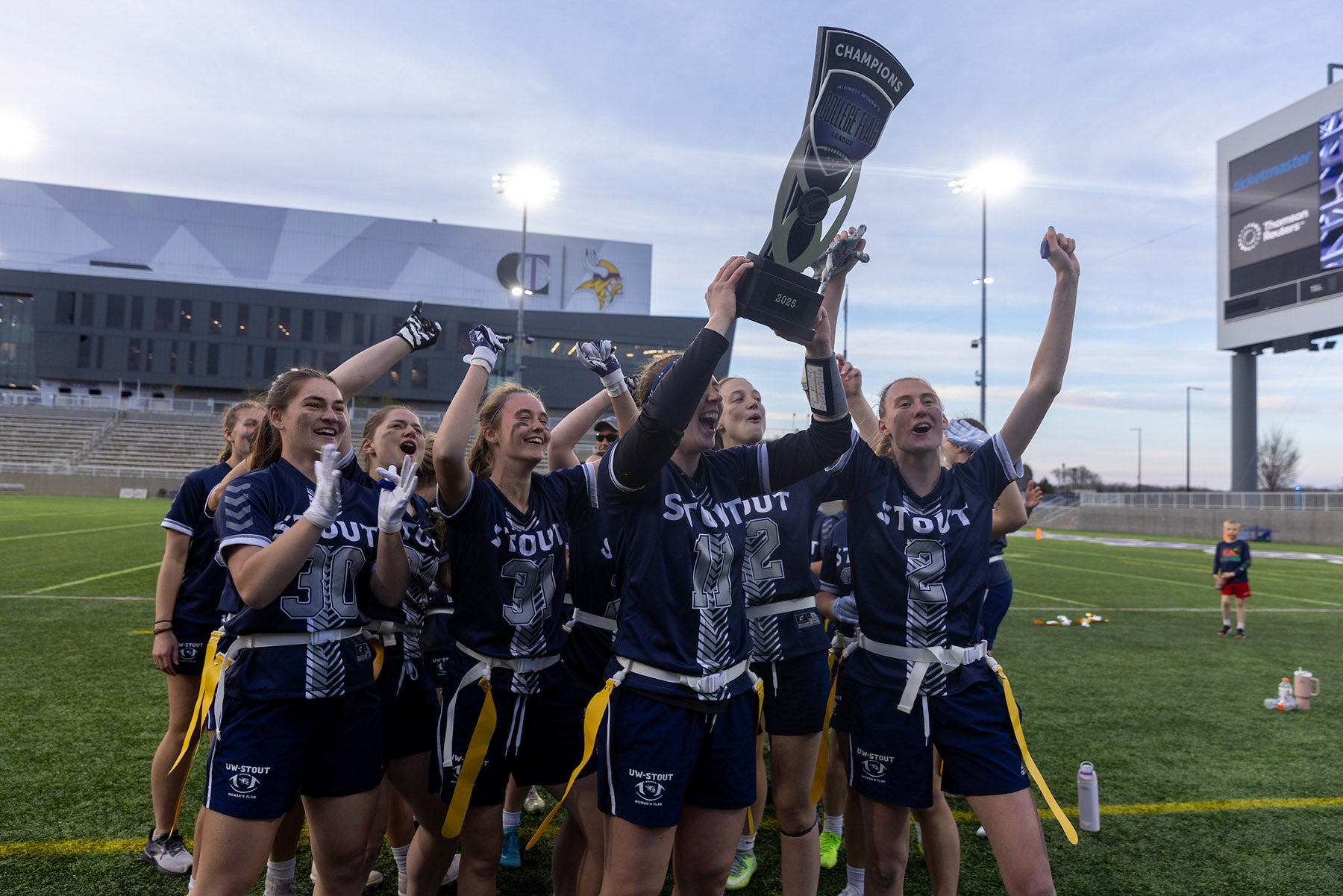 Flag football players celebrate with a trophy