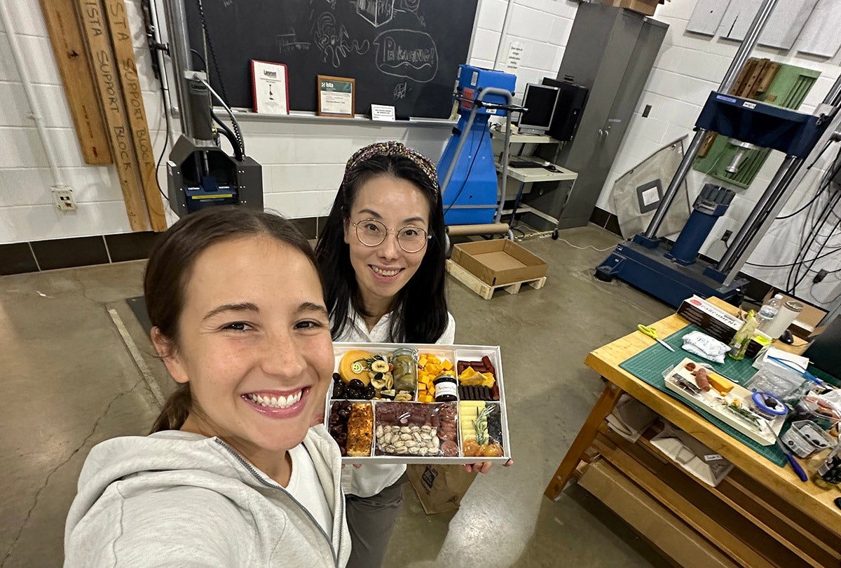 Two women pose with charcuterie