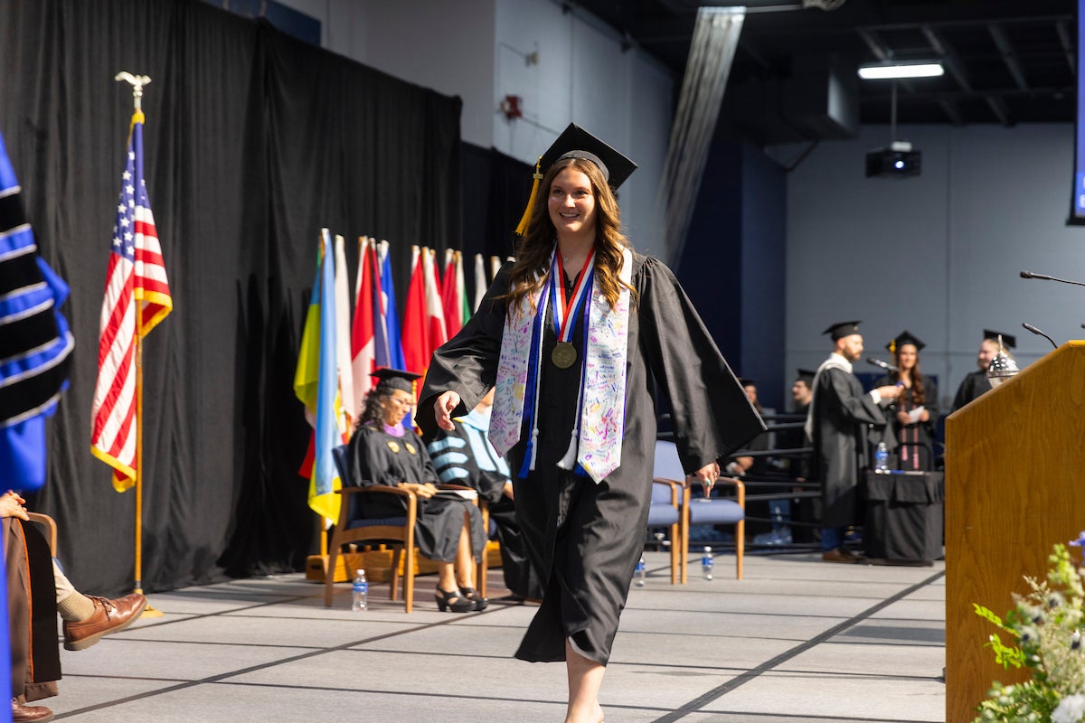 Kloie Potts crosses the commencement stage at graduation
