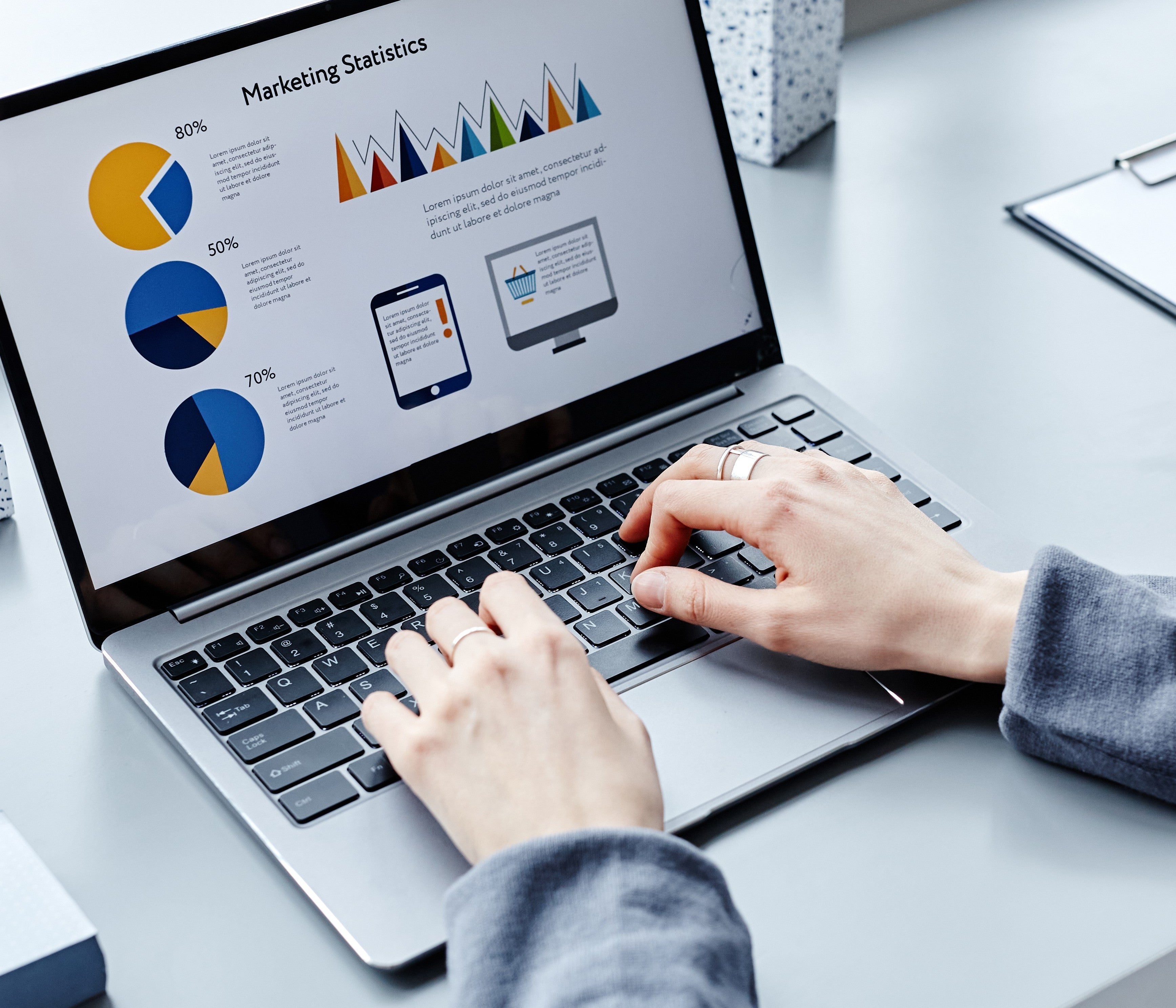 Person typing marketing statistics onto Laptop
