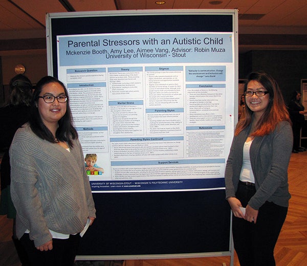 Aimee Vang, left, and Amy Lee present research on the stress felt by parents of an autistic child.