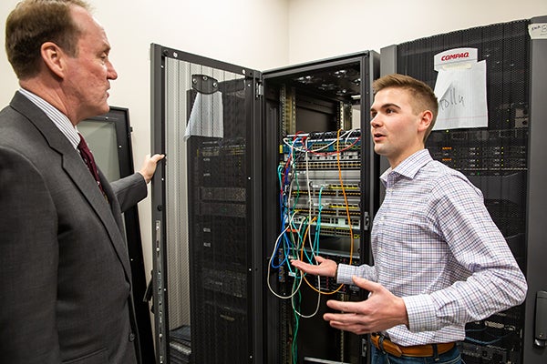 Student Sam Wosika, right, talks about the data center at the Computer Networking and Cyber Security labs with Timothy Nagle, chief privacy officer for U.S. Bank.