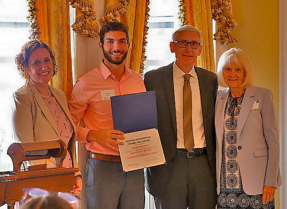 Cameron Hunter, second from left, receives a Champion of Change Award from Gov. Tony Evers, third from left.