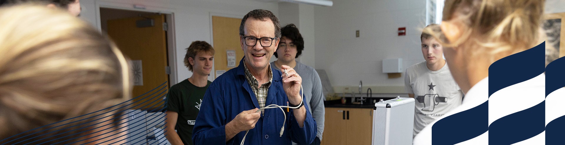 Professor performs lab demonstration for students.