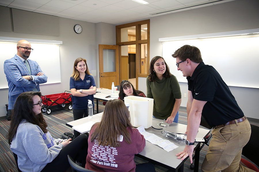 Associate professor John Spartz, at left, talks with students and Colin Marklowitz, at right, a 2014 professional communication and emerging media alumnus and digital media producer for the Kitchen and Bath Americas group at Kohler Co. Marklowitz was a recent guest speaker at the class. Next to Spartz is Alana Rucks, a junior PCEM major, who is a technical writer inter for Kohler bath products.