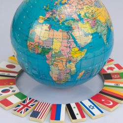 World globe with different flags laying around the globe.