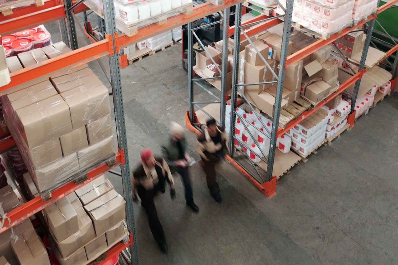 Image of workers walking under scaffolding with hard hats on