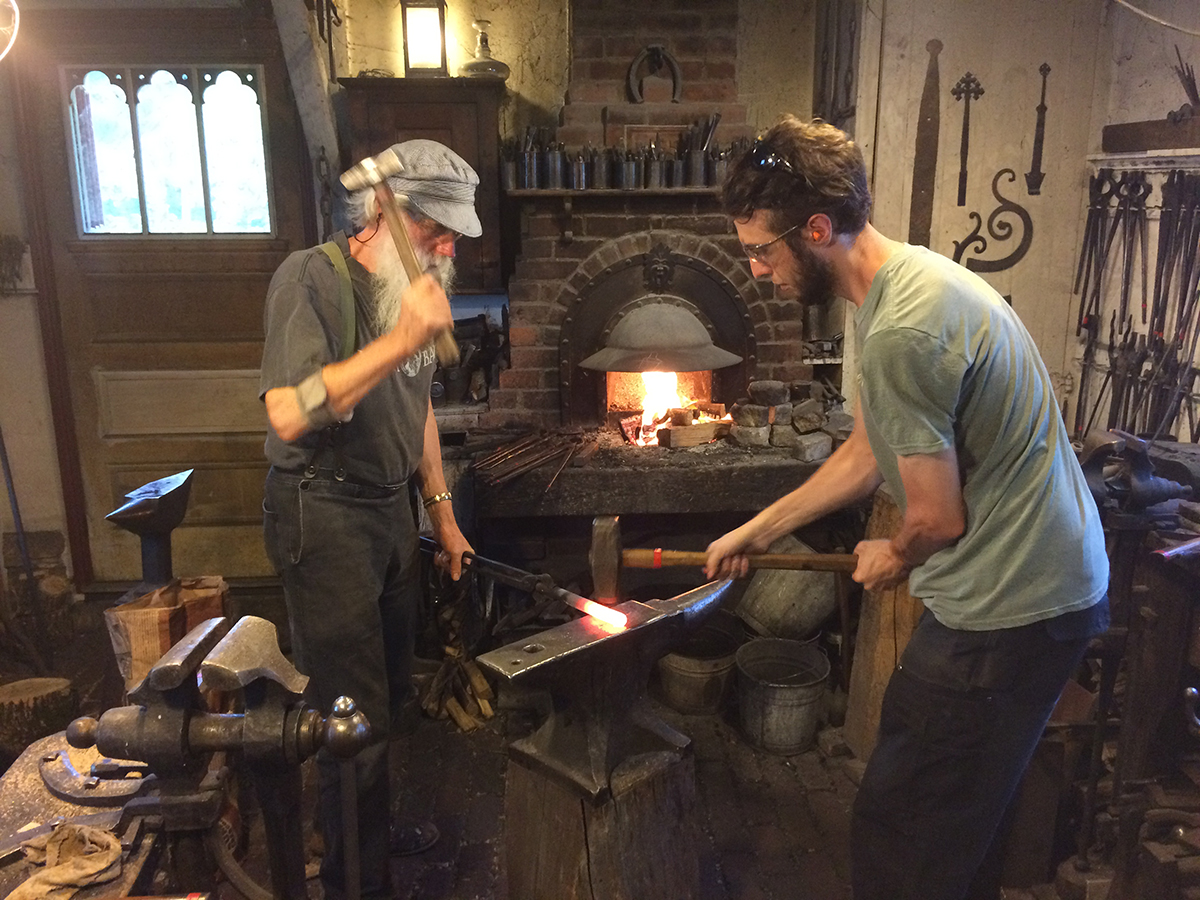 ​    ​Pepin blacksmith Tom Latané, at left, works in his shop with fellow blacksmith Joe Lech. UW-Stout graduate Aidan Cochrane did his field experience for his professional media and emerging media chronicling the creation of handcrafted items through pictures and words.