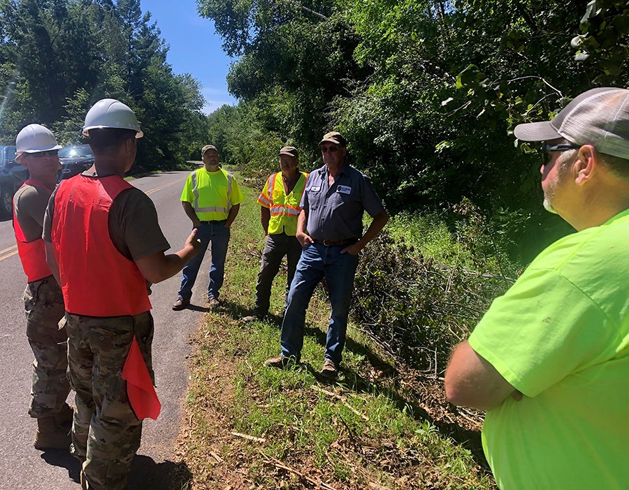 Wisconsin National Guard members, left, speak with township and county officials in Barron County during their storm cleanup operation.