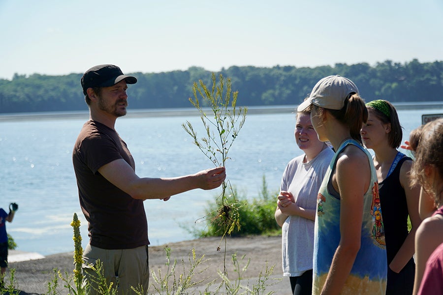 UW-Stout senior biology lecturer Arthur Kneeland talks with LAKES REU students about a rain garden on Lake Menomin./UW-Stout photo Chris Ferguson