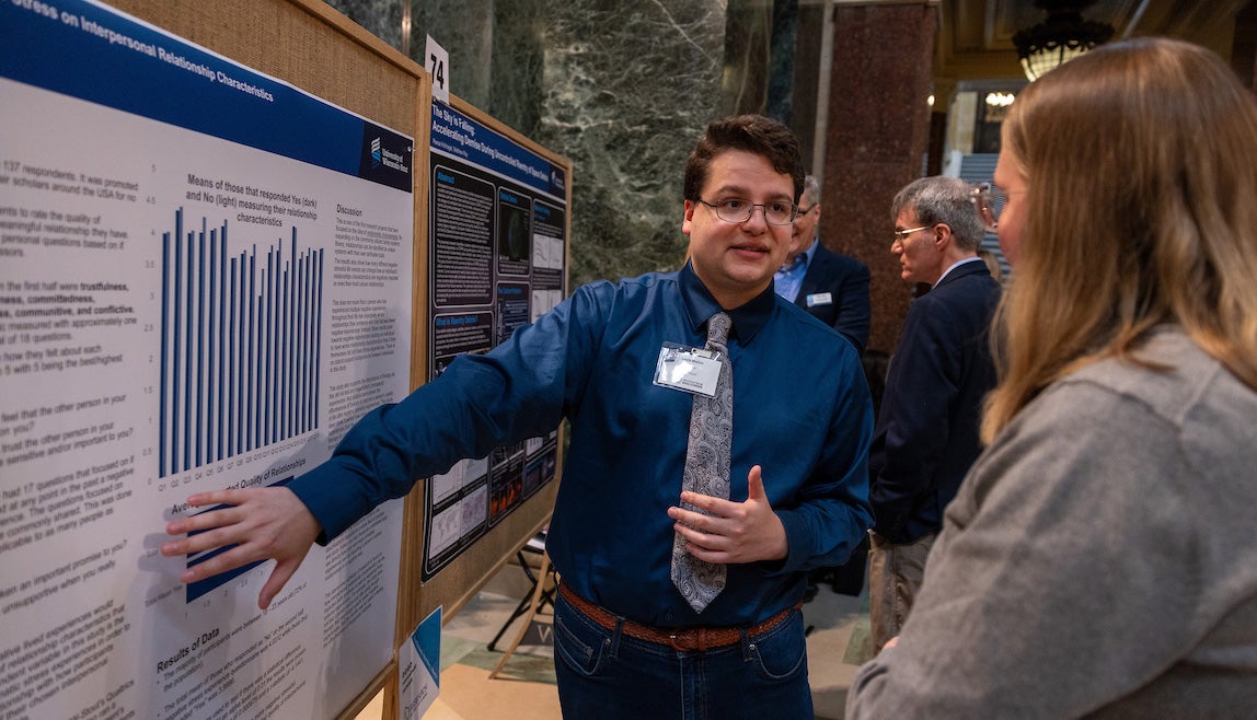 A Stout student presents his research in the Madison Capitol building during Research in the Rotunda.