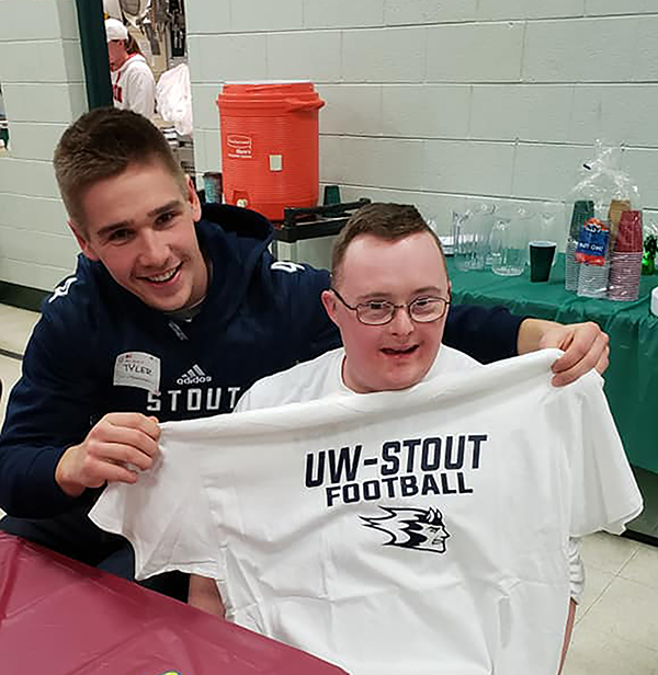 UW-Stout athlete Tyler Seymour gives a Blue Devils T-shirt to a Special Olympics athlete at a recent event.