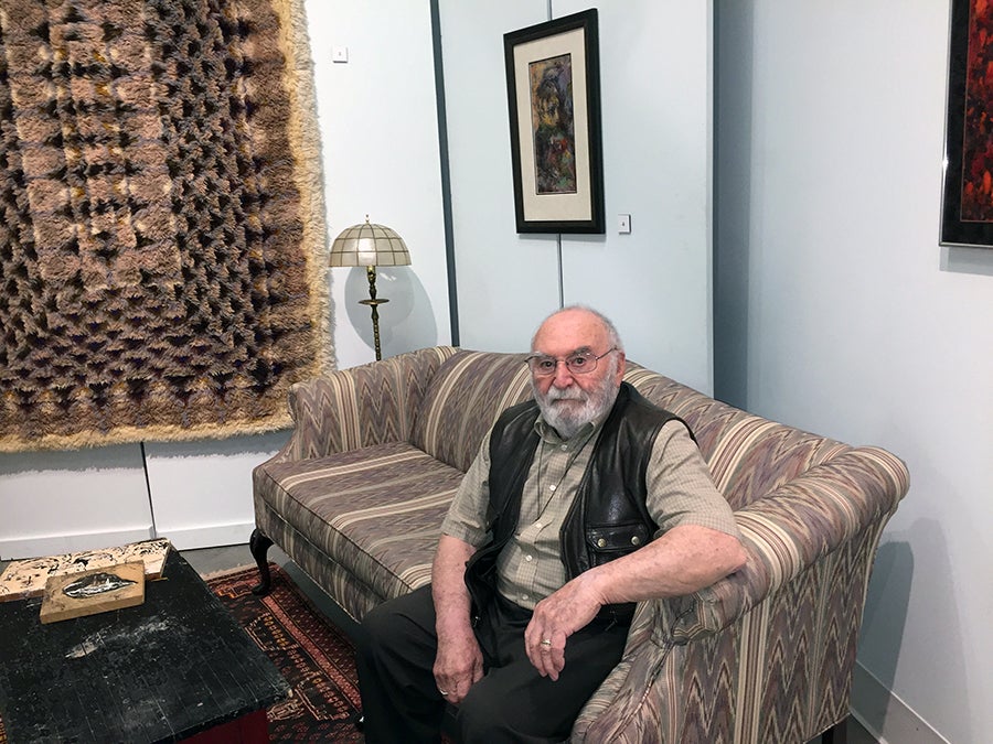 William Schulman on a couch that is part of the exhibit