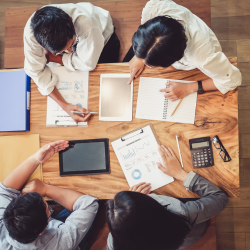 team of 4 sitting on a table with some marketing materials on the table
