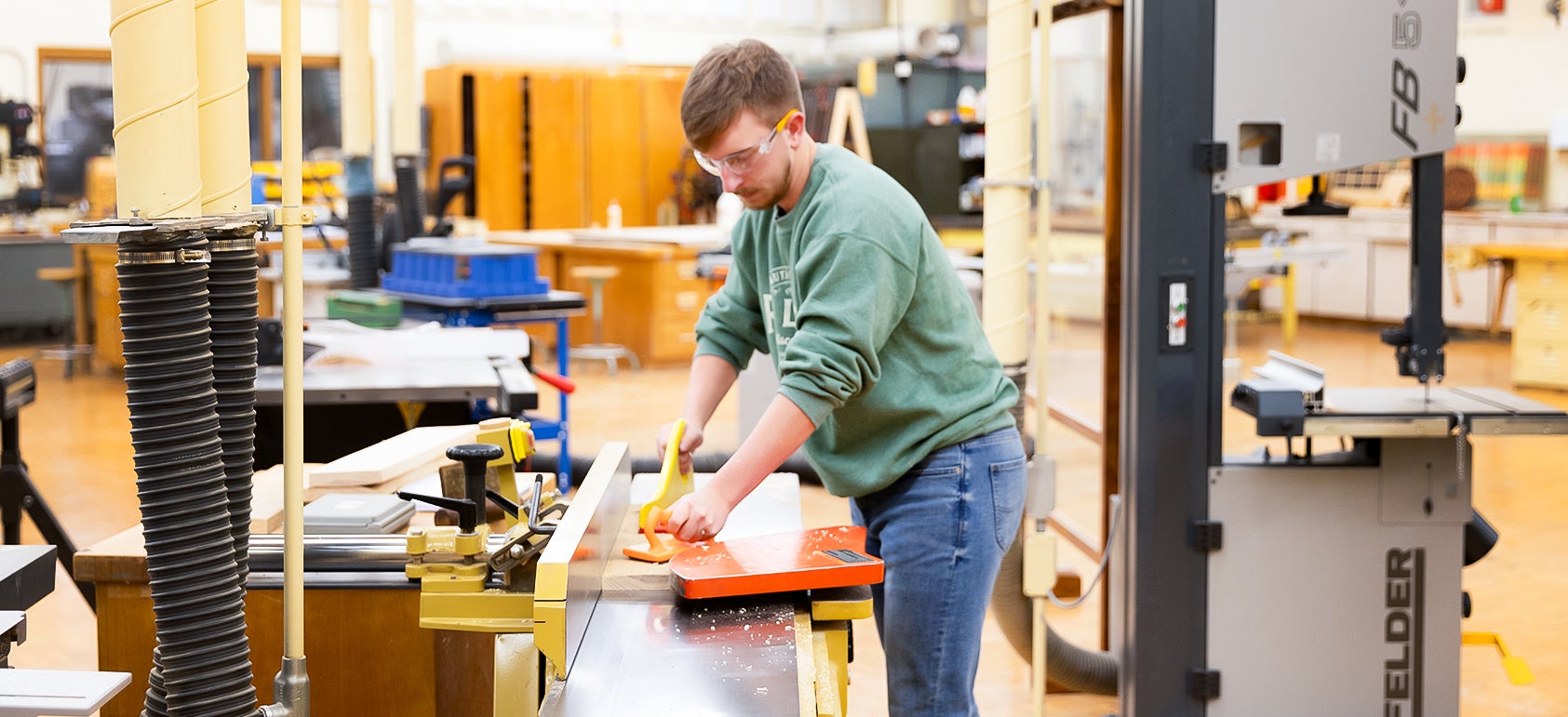 Student uses planer in lab space.