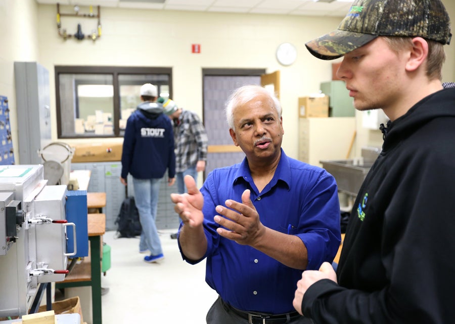 Rajiv Asthana works with students in a lab.