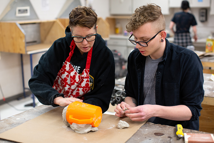 UW-Stout’s Jennifer Astwood, left, a design professor, works with a student on ceramic mugs, part of the Made at UW-Stout initiative.