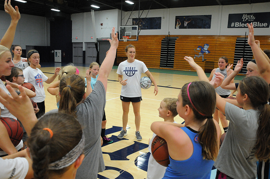 UW-Stout basketball players work with girls at a 2018 summer camp.