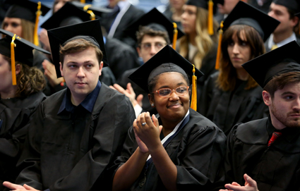 Graduates clap during the morning ceremony Saturday.
