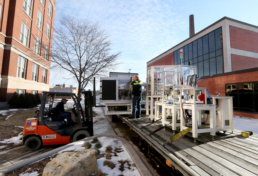 The equipment is removed from a flatbed truck and headed for Fryklund Hall, right.