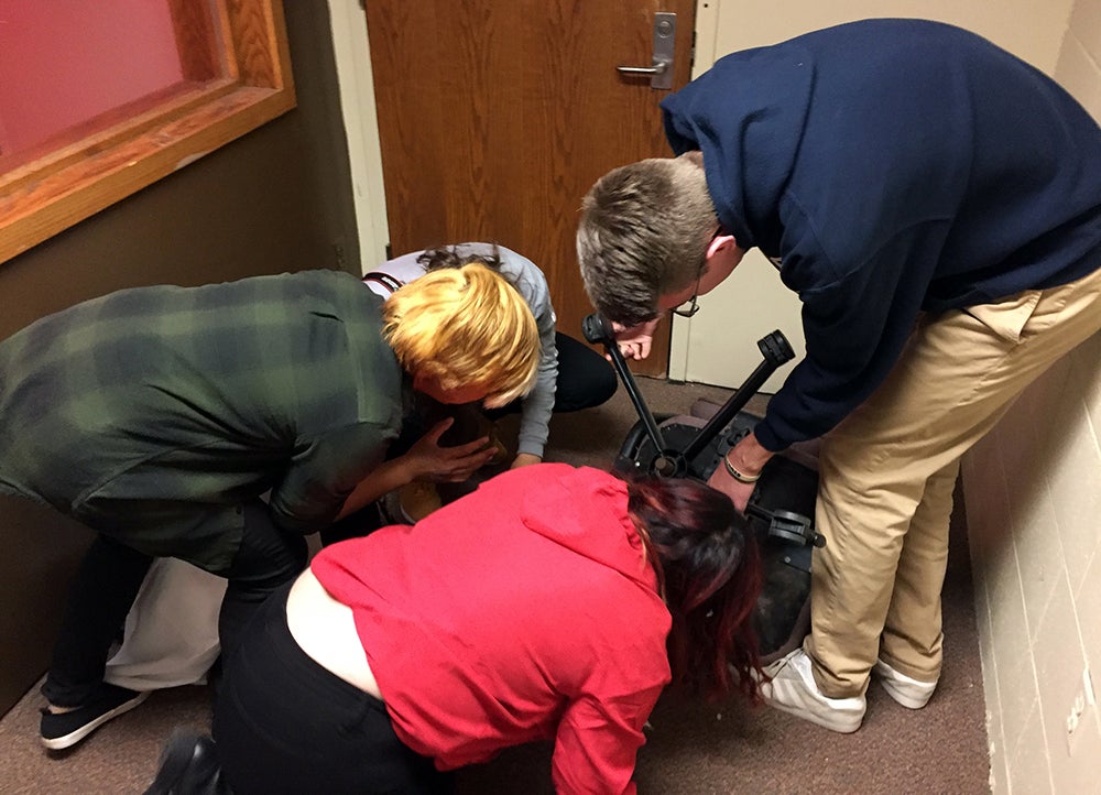 Team members, left to right, Nicole Juza, Theresa Hang, Chia Lor and Sam Giesregen, search for clues in the Jurassic Stout escape room.