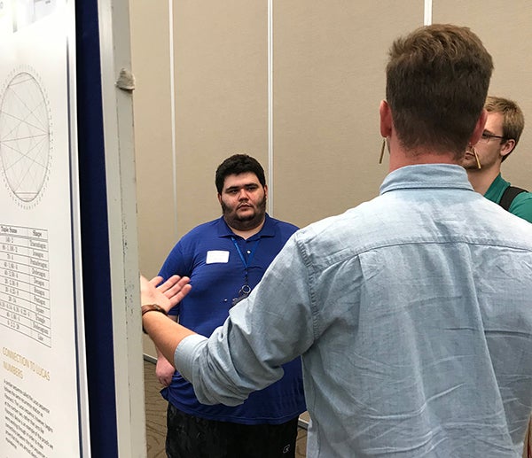 James Evans, left, talks with other student researchers from the McNair Scholars Program.