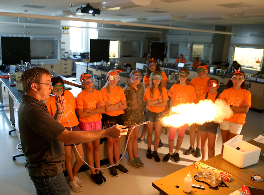 Matthew Ray, UW-Stout associate professor, demonstrates dust explosions and combustion of dust, to STEPS campers.