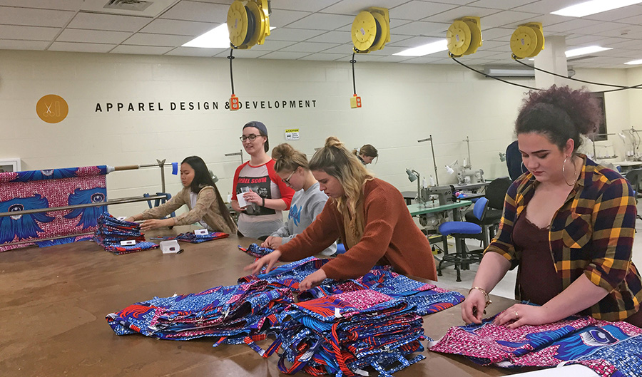 Nkao Hle Hang, at left, Sofia Van Tassel, Kennedy Gorres, Courtney Schmitt and Brynnda Foster fold skirts made by apparel design and development students as demo models for Hope Sewn.