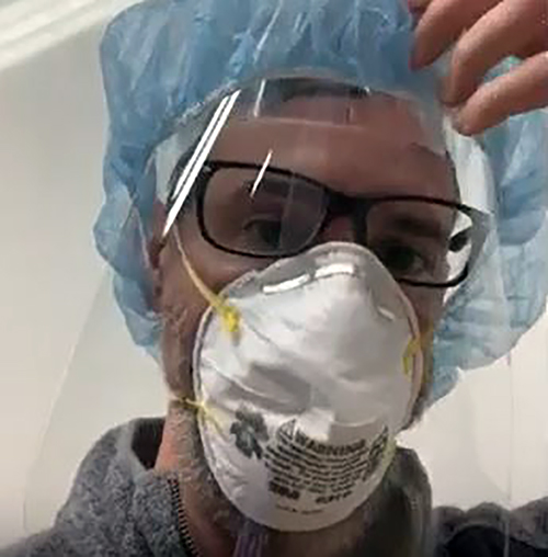 A worker at Franzen Graphics/Sun Media demonstrates a clear plastic face shield to help protect health care and other workers during the pandemic. The Sheboygan company, which is making up to 10,000 shields a day, was founded by a UW-Stout alumnus.
