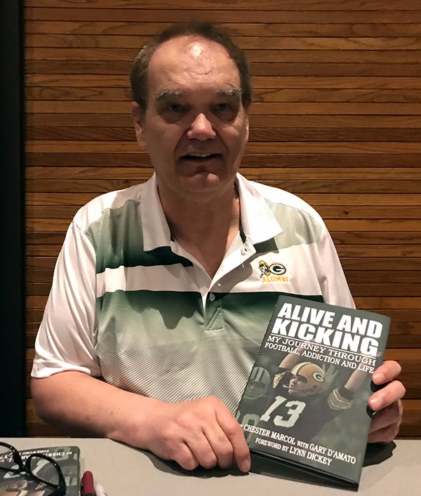 Chester Marcol signs copies of his book, “Alive and Kicking,” after speaking at UW-Stout at the 35th annual National Rural Institute on Alcohol and Drug Abuse.