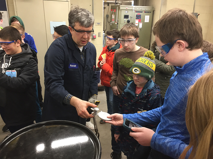 St. Croix Central students look at the UW-Stout medallion cast in the foundry.