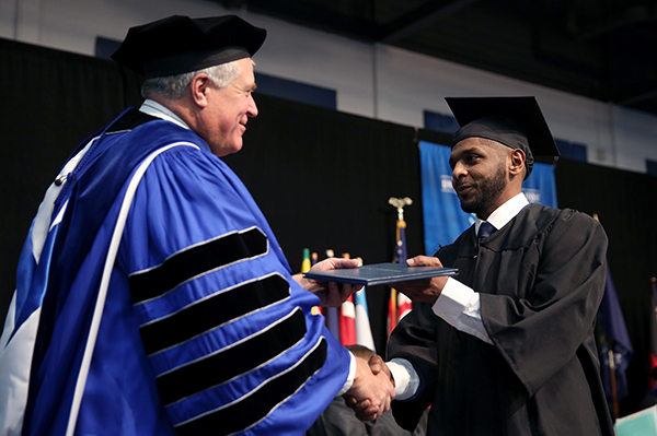 Chancellor Bob Meyer presents a diploma to a graduate in December 2017.