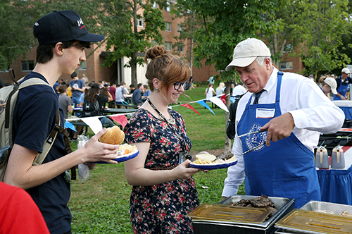 Chancellor Bob Meyer  serves food to students during the Great American Cookout on campus in fall of 2015.
