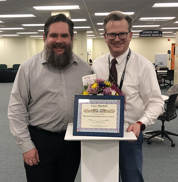 Librarian Cory Mitchell, left, recipient of the 2019 Barnard Outstanding Service Award from the University Library, celebrates with Scott Vrieze, library director.