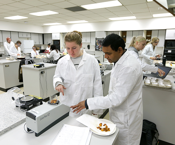 Faculty member Pranabendu Mitra, right, works with a student in the Food Product Development class.