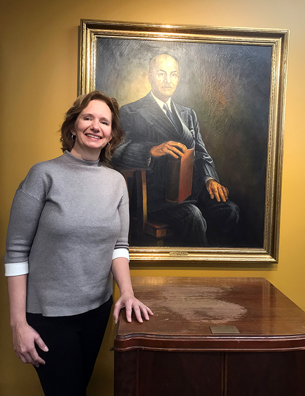 Stephanie Nelson Perry saw the official portrait of her great-grandfather, Burton Nelson, when she visited UW-Stout recently for the first time. In front of the portrait is a cabinet that belonged to Nelson