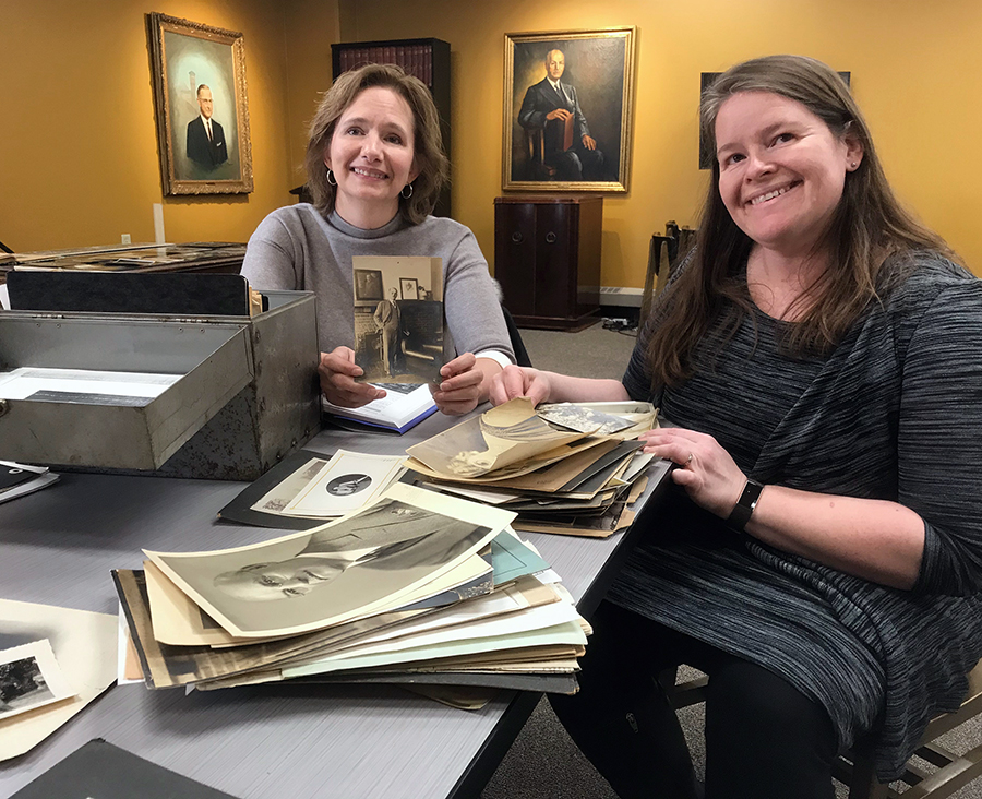 Perry provided University Archivist Heather Stecklein, right, with photos and family history related to her great-grandfather, former UW-Stout President Burton Nelson. Between them in the background is Nelson’s portrait.